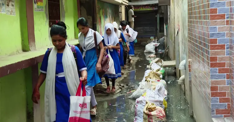 জমে থাকা ময়লা পানি পেরিয়ে স্কুলে যাচ্ছে শিক্ষার্থীরা